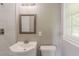 Modern bathroom featuring white tiling, a wooden-framed mirror, and contemporary fixtures at 4447 Ben Hill Rd, Lithia Springs, GA 30122