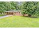 Charming one-story brick home with a well-maintained lawn and mature trees providing ample shade at 4447 Ben Hill Rd, Lithia Springs, GA 30122