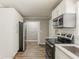Beautiful kitchen with stainless steel appliances, white cabinets, and hardwood floors at 4447 Ben Hill Rd, Lithia Springs, GA 30122
