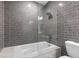 Modern bathroom features tiled shower-tub, a glass partition, and a white toilet at 950 Nw W Peachtree Nw St # 410, Atlanta, GA 30309