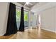Bedroom features hardwood floors, ceiling fan, and sliding glass doors with black curtains at 950 Nw W Peachtree Nw St # 410, Atlanta, GA 30309