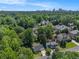 Aerial view shows a suburban neighborhood with lush trees and a skyline view in the distance at 1175 Haven Brook Way, Atlanta, GA 30319