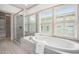 Bright bathroom featuring a soaking tub, glass-enclosed shower, and large window at 1216 Virginia Ne Ct # 8, Atlanta, GA 30306