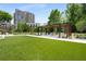 Lush green lawn with a pergola-covered seating area and barbecue grills in a well-maintained outdoor space at 2660 Peachtree Nw Rd # 10H, Atlanta, GA 30305