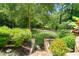 Stone staircase leading to a lush green backyard with mature trees and manicured landscaping at 3770 Riverly Trce, Marietta, GA 30067