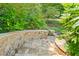 Stone stairs leading down to a beautifully landscaped backyard with lush greenery and mature trees at 3770 Riverly Trce, Marietta, GA 30067