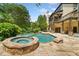 Spacious backyard with a pool and hot tub, surrounded by mature trees and a stone patio at 3770 Riverly Trce, Marietta, GA 30067