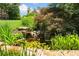 Picturesque pond with stone waterfall, surrounded by vibrant flowers and lush foliage at 3770 Riverly Trce, Marietta, GA 30067