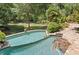Beautiful in-ground pool with lush landscaping and stone patio, creating a serene backyard oasis at 3770 Riverly Trce, Marietta, GA 30067