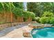 Backyard pool with integrated hot tub featuring lush landscaping and stone retaining walls for privacy at 3770 Riverly Trce, Marietta, GA 30067
