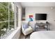 Relaxing bedroom featuring a chair, artwork, and a large window showcasing outside greenery at 22 Airline Ne St # 201, Atlanta, GA 30312