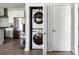 Convenient stacked laundry unit in a closet with a view of the modern kitchen at 22 Airline Ne St # 201, Atlanta, GA 30312