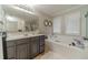 Bright bathroom with a large vanity, soaking tub, and decorative mirror at 568 Musical Ct, Lawrenceville, GA 30044