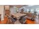 Open-concept dining area with hardwood floors, a granite-top table, and staircase views at 568 Musical Ct, Lawrenceville, GA 30044