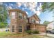 Beautiful two-story home with a stone accent turret and brown siding, complemented by lush greenery at 568 Musical Ct, Lawrenceville, GA 30044