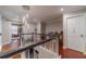 Upstairs landing with decorative lighting, railing, and dark wood floors leading to multiple rooms at 568 Musical Ct, Lawrenceville, GA 30044