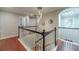 Upstairs landing and hallway featuring wood floors, decorative lighting fixtures, and elegant black and white railings at 568 Musical Ct, Lawrenceville, GA 30044