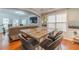 Open-concept living room featuring wood floors, a stone countertop table and large windows at 568 Musical Ct, Lawrenceville, GA 30044