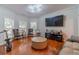 Bright living room featuring hardwood floors, large windows, and modern lighting fixtures at 568 Musical Ct, Lawrenceville, GA 30044