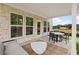 Covered patio with stone columns features a table and seating with a view of the backyard at 5760 Tillman Way, Powder Springs, GA 30127