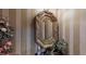 Close-up of a powder room featuring a gold mirror with decorative floral elements and elegant wallpaper at 2901 Briscoe Rd, Loganville, GA 30052