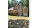 Back exterior view showcasing a deck, walkout basement, neutral siding and trim, and wooded backyard at 2901 Briscoe Rd, Loganville, GA 30052