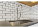 Close-up of a stainless steel sink with modern faucet and white subway tile backsplash at 355 Winding River Dr # B, Atlanta, GA 30350