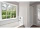 Bright bathroom featuring a white tub, tiled walls, and a large window at 76 Vaughn Ne Rd, Cartersville, GA 30121