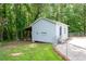 View of the outbuilding with vinyl siding and a chain-link fence, situated near mature trees at 76 Vaughn Ne Rd, Cartersville, GA 30121