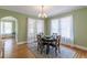Dining room with hardwood floors, a round table, and sheer curtains filtering natural light through multiple windows at 1391 Jefferson Ave, East Point, GA 30344