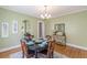 Traditional dining room with a round table set for four, decorative chandelier, and light green walls at 1391 Jefferson Ave, East Point, GA 30344