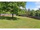 Spacious backyard with manicured lawn, mature trees, and wooden fence perfect for outdoor activities at 174 Randall Dr, Rockmart, GA 30153