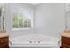 Bright bathroom featuring a corner soaking tub under a window and double vanities at 174 Randall Dr, Rockmart, GA 30153