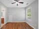 A bright bedroom features hardwood floors, ceiling fan, and large window for natural light at 174 Randall Dr, Rockmart, GA 30153