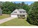Two-story home with a two-car garage, manicured lawn, and mature landscaping creating curb appeal at 174 Randall Dr, Rockmart, GA 30153