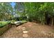 A spacious backyard with mature trees, lush landscaping, and stone pathway to pool at 3228 Turtle Lake Se Dr, Marietta, GA 30067