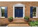 A close-up of the brick home's entrance with an elegant blue door and potted plants at 3228 Turtle Lake Se Dr, Marietta, GA 30067