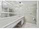 A well-lit bathroom with double sinks, modern lighting, and white tile flooring at 6851 Roswell Rd # H18, Atlanta, GA 30328