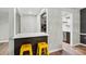 Open dining area with a breakfast bar, modern countertop, bright yellow stools, and seamless wood flooring at 6851 Roswell Rd # H18, Atlanta, GA 30328