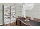A stylish dining room illuminated by a modern chandelier, with seating and built in shelving unit at 6851 Roswell Rd # H18, Atlanta, GA 30328