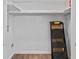 A minimalist laundry room with white walls, wood floors, and space-saving shelving at 6851 Roswell Rd # H18, Atlanta, GA 30328