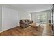 Living Room featuring wood floors, a large window, a couch, and a storage closet at 6851 Roswell Rd # H18, Atlanta, GA 30328