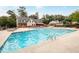 Community swimming pool with lounge chairs, surrounded by lush greenery, and nearby clubhouse at 6851 Roswell Rd # H18, Atlanta, GA 30328