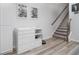 Hallway with modern decor, featuring a dresser and stairway with carpeted steps and wood railing at 1825 Villageside Ct, Lawrenceville, GA 30043