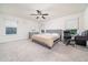 Main bedroom featuring a ceiling fan, a bed, and a desk, with ample natural light from the windows at 1825 Villageside Ct, Lawrenceville, GA 30043