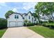 Beautiful home with a lush green lawn, mature trees, and a two-car garage at 3065 Foxhall Overlook, Roswell, GA 30075