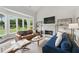 Open-concept living room features a fireplace, large windows, hardwood floors, and comfortable seating at 3065 Foxhall Overlook, Roswell, GA 30075