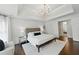 Bright main bedroom featuring hardwood floors, a tray ceiling and access to an ensuite bathroom at 3065 Foxhall Overlook, Roswell, GA 30075