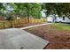 A spacious backyard featuring a concrete pad, a wood fence, and a charming home exterior at 1283 Beecher Sw St, Atlanta, GA 30310