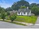 Charming home with dormer windows and a blue front door sits on a well-manicured lawn, surrounded by trees at 1283 Beecher Sw St, Atlanta, GA 30310